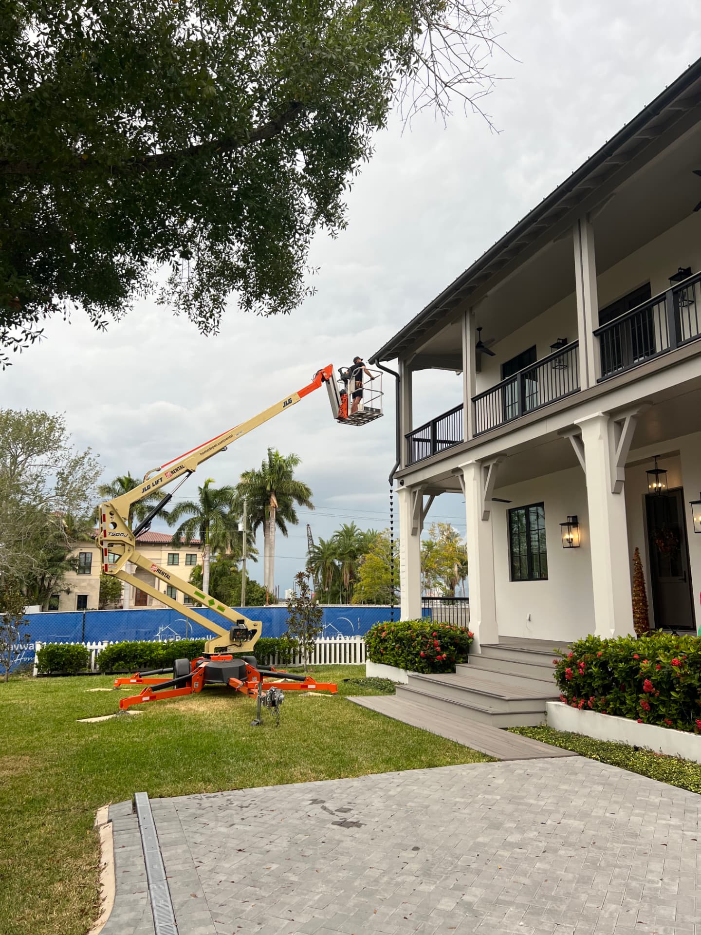 Happy Holiday Light Contractors crew working from a boom lift on a Palm Harbor home
